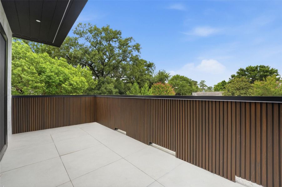 An expansive upstairs terrace offers a private outdoor retreat with plenty of room for lounge seating, entertaining, and enjoying the surrounding treetop views