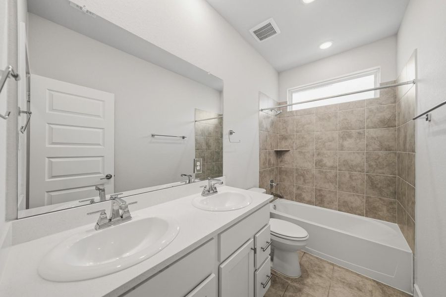 Bright secondary bath with dual sinks and a functional layout designed for everyday convenience. Bright secondary bath with dual sinks and a functional layout designed for everyday convenience.