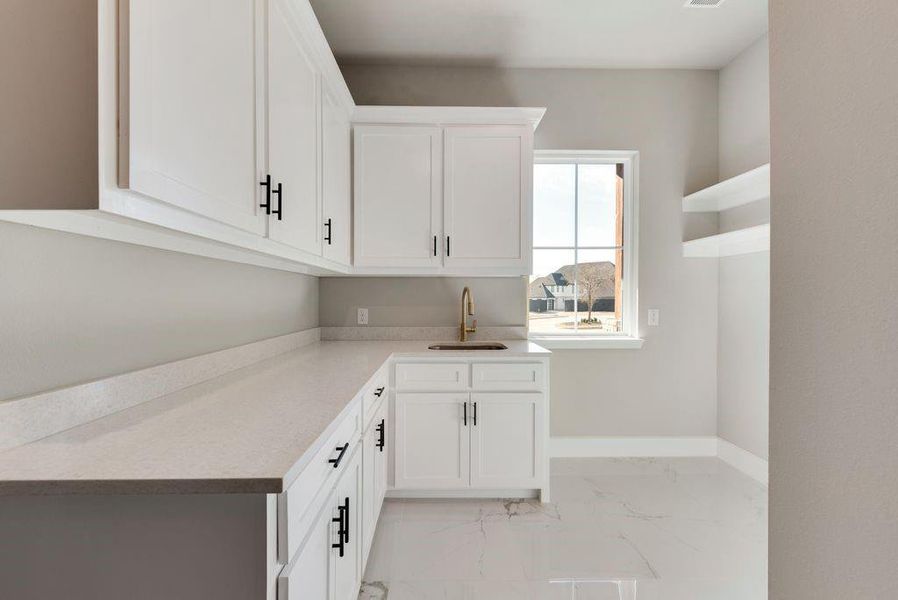 Kitchen featuring sink and white cabinetry