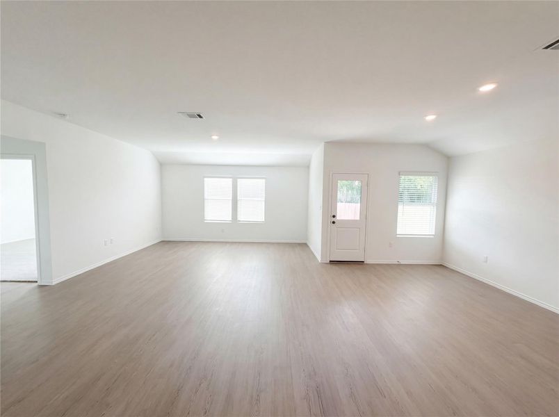 Empty room with light wood finished floors, recessed lighting, and lofted ceiling