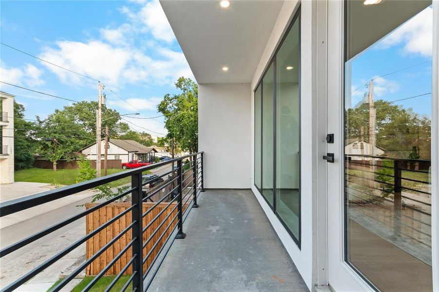 Private balcony featuring a concrete surface, black horizontal bar railing, and recessed lighting Private balcony featuring a concrete surface, black horizontal bar railing, and recessed lighting