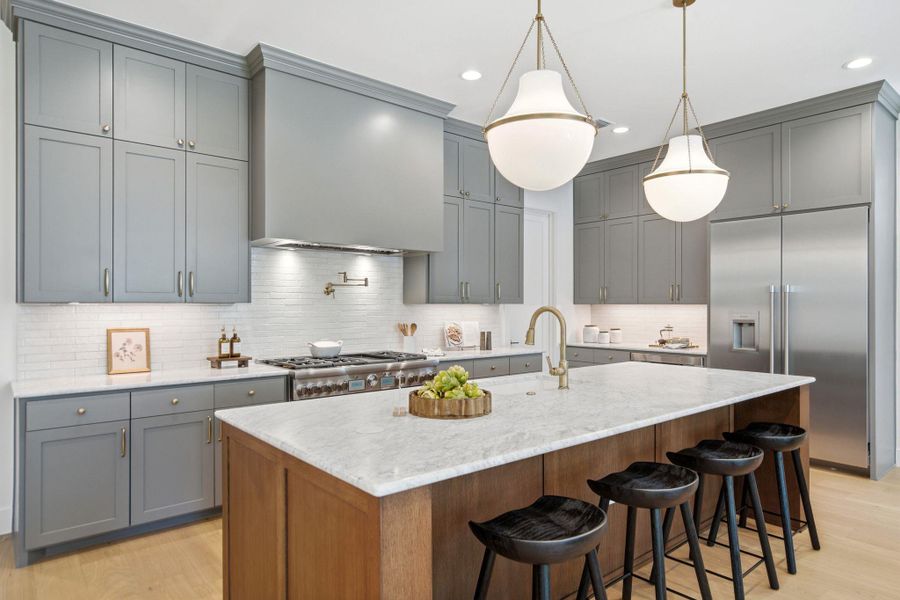 Premium stone countertops and detailed cabinetry anchor this beautifully crafted kitchen space.