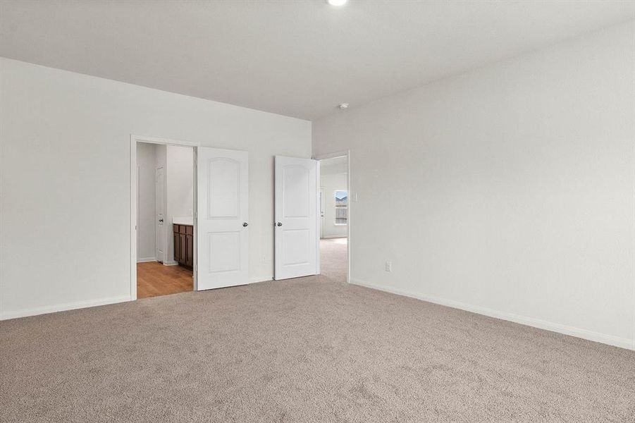 Unfurnished bedroom featuring light colored carpet and ensuite bath