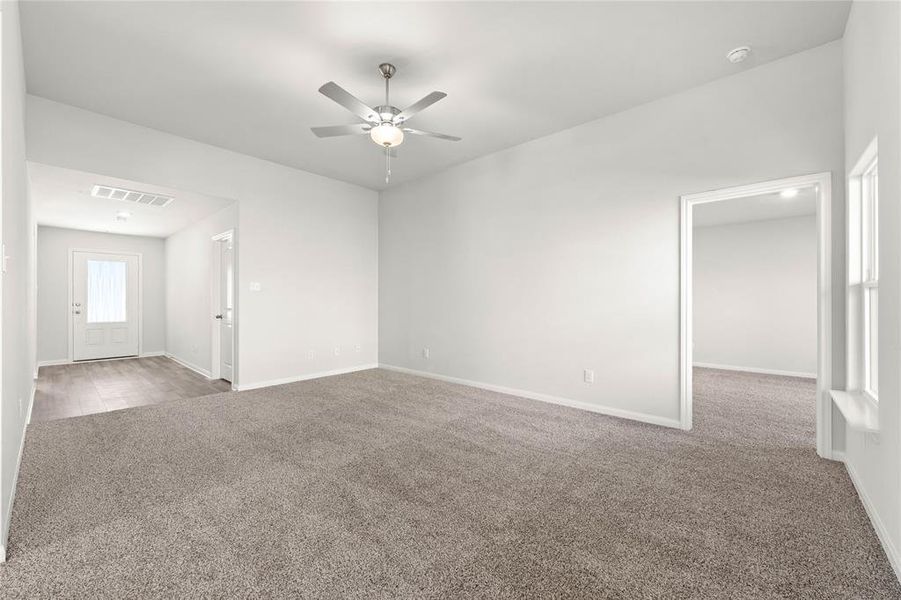 Carpeted spare room with ceiling fan, baseboards, and a smoke detector