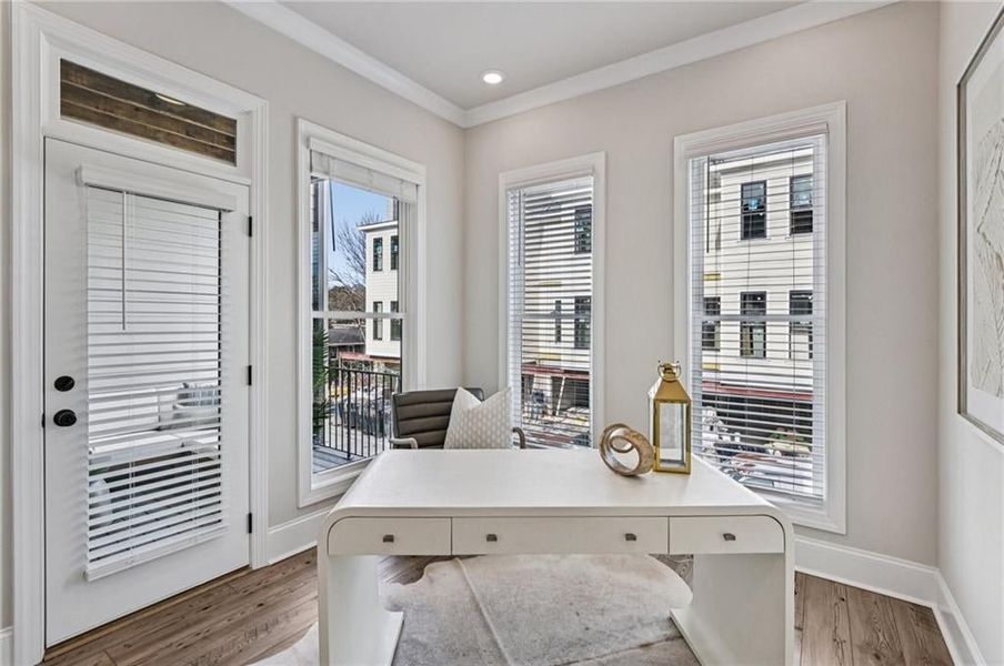 Home office with ornamental molding and light wood finished floors