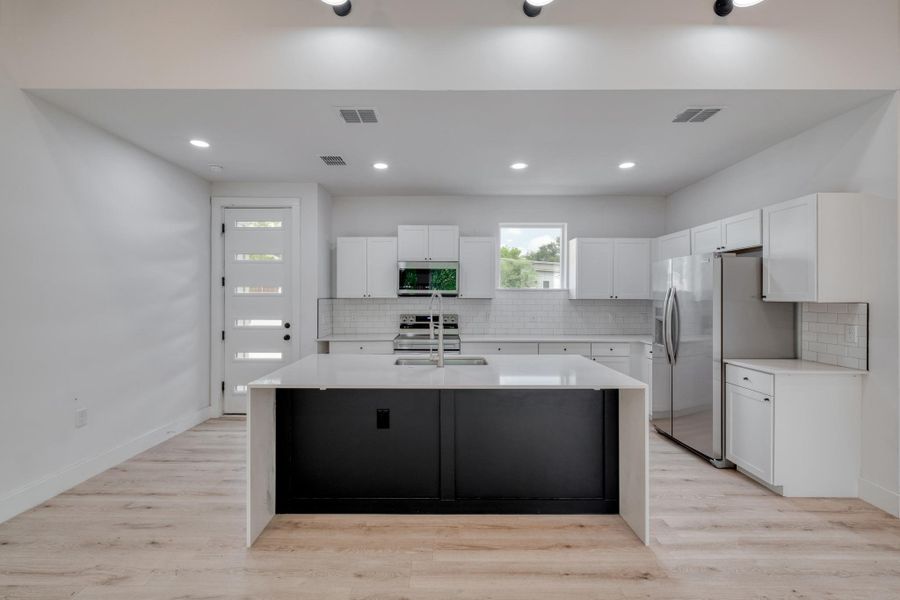 A sleek island anchors this bright kitchen, complete with stainless steel appliances and abundant cabinetry. A sleek island anchors this bright kitchen, complete with stainless steel appliances and abundant cabinetry.
