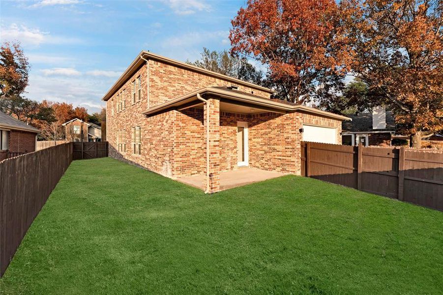 Rear view of property with a yard and a patio