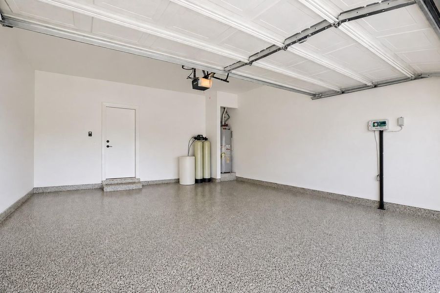 A well-maintained garage features durable epoxy flooring and convenient utility access. A well-maintained garage features durable epoxy flooring and convenient utility access.