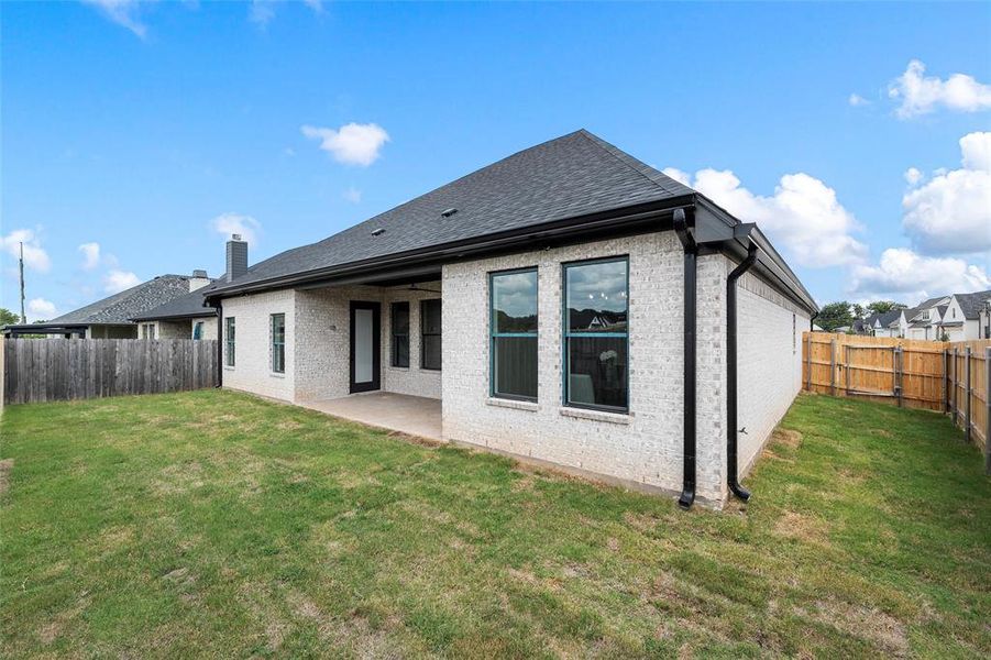 Back of property featuring brick siding, a patio area, a fenced backyard, and roof with shingles Back of property featuring brick siding, a patio area, a fenced backyard, and roof with shingles