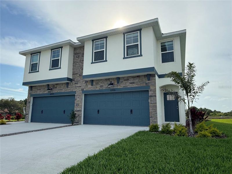 Front exterior of a new home in Emerald Fields, Hudson, FL, highlighting curb appeal (Image 1).