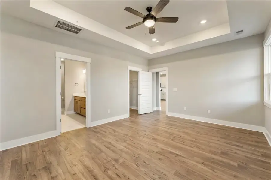 A spacious primary bedroom features hardwood floor