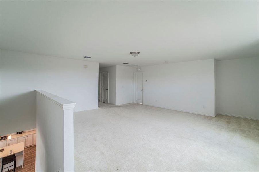 Spare room with light colored carpet and baseboards Spare room with light colored carpet and baseboards