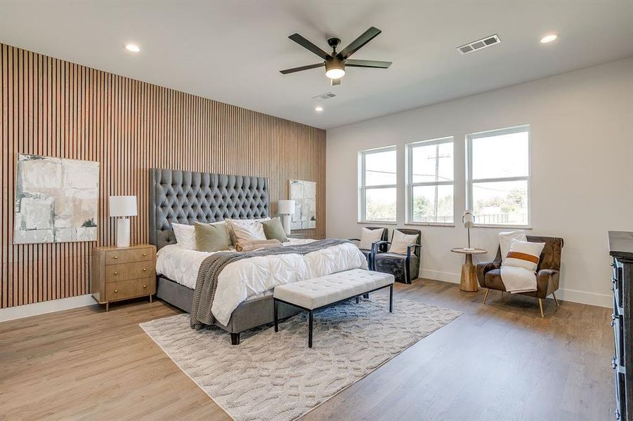Bedroom featuring recessed lighting, light wood-type flooring, an accent wall, ceiling fan, and wood walls Bedroom featuring recessed lighting, light wood-type flooring, an accent wall, ceiling fan, and wood walls