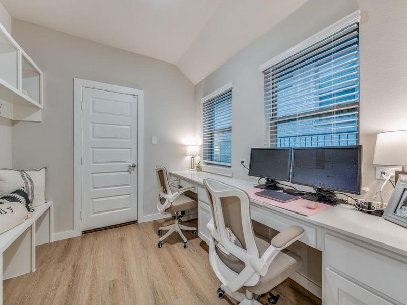 Office space with plenty of natural light and vinyl plank flooring. Featuring a mud bench and storage as well