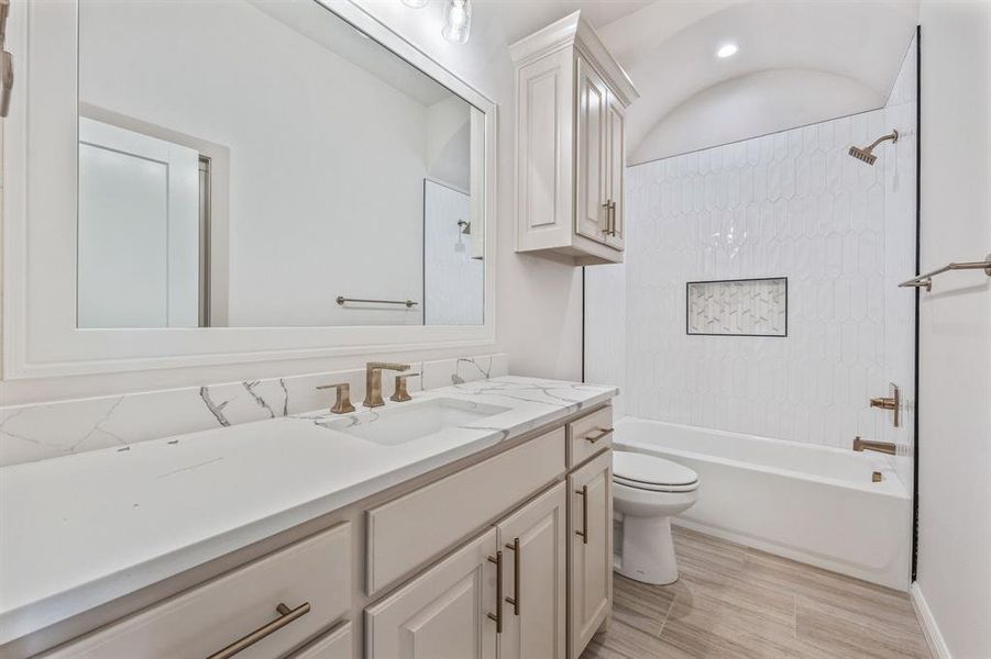 Bathroom featuring toilet, shower / tub combination, and vanity