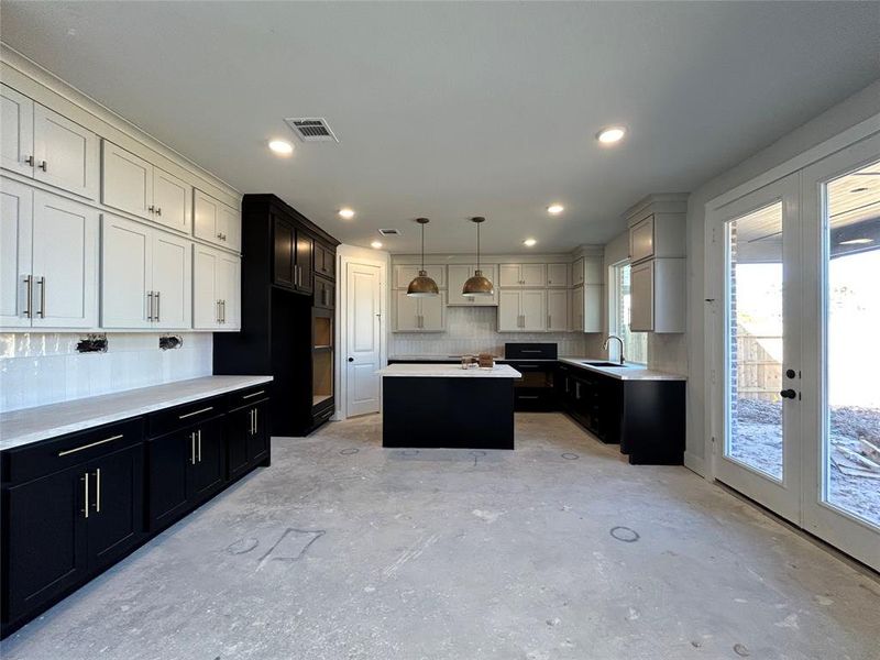 The kitchen area flows seamlessly into the living room, creating an open, airy space where the warmth of cooking blends effortlessly with the comfort of the living area.