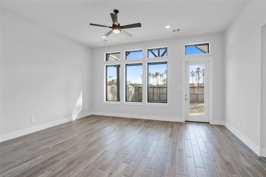 Soaring, tall windows frame the living space, bathing the room in natural light and highlighting the architectural volume of the space. A convenient back door provides direct and easy access to a comfortable covered patio, effortlessly extending your living space outdoors for year-round enjoyment and entertaining. Soaring, tall windows frame the living space, bathing the room in natural light and highlighting the architectural volume of the space. A convenient back door provides direct and easy access to a comfortable covered patio, effortlessly extending your living space outdoors for year-round enjoyment and entertaining.