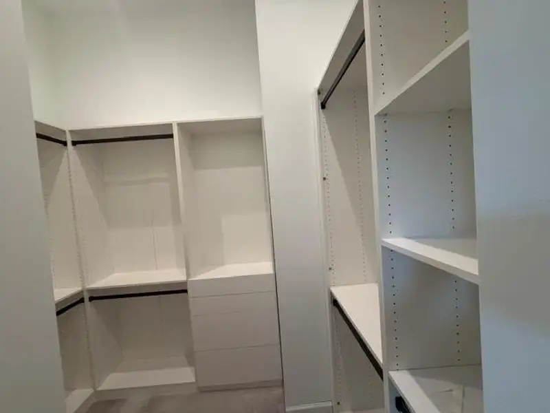 Expansive walk-in closet with custom shelving and ample storage space, perfect for organizing your wardrobe.