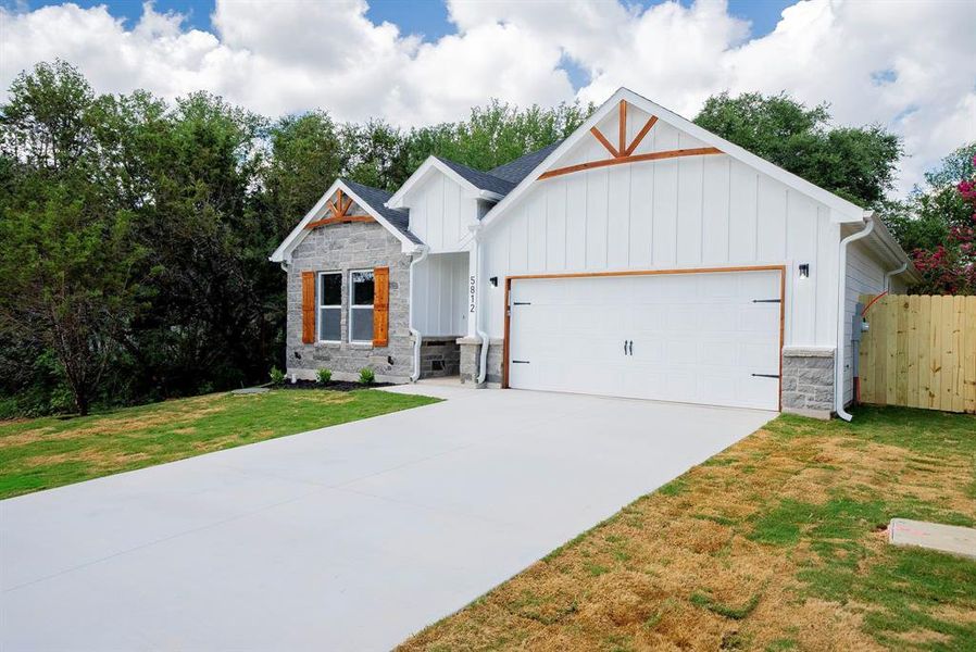 Modern farmhouse style home with a front yard and a garage