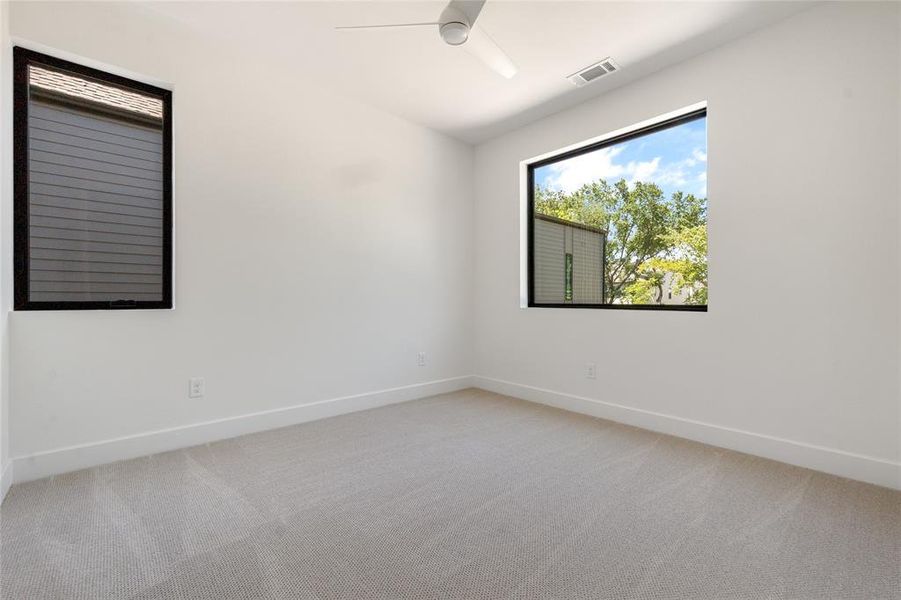 Carpeted empty room with ceiling fan