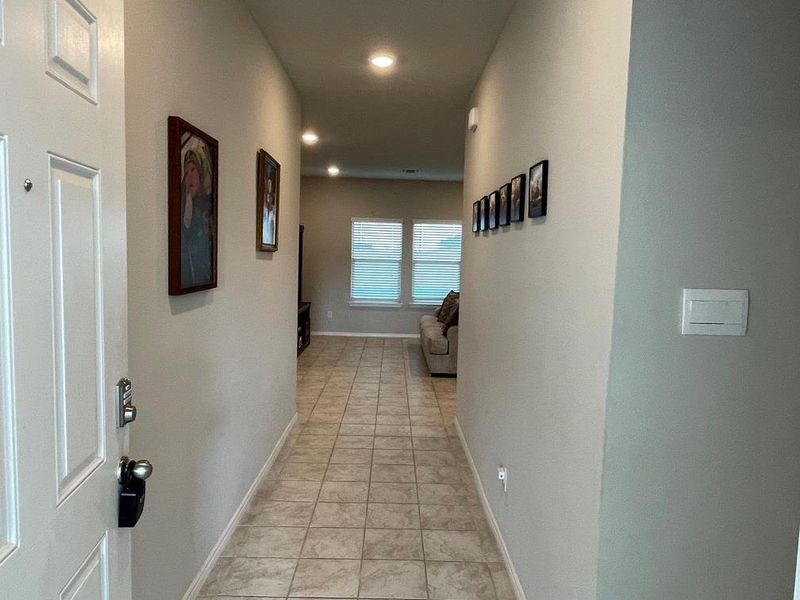 Corridor with light tile patterned floors and recessed lighting