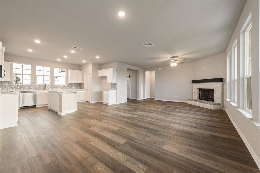 Unfurnished living room with a fireplace, dark wood-style flooring, recessed lighting, and ceiling fan