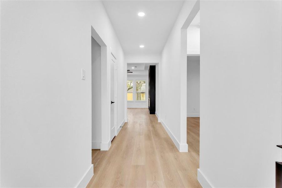 Hallway with light wood-style flooring and recessed lighting