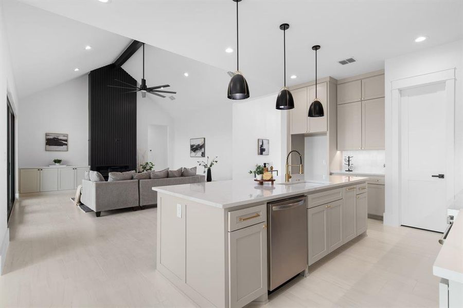 Kitchen with an island with sink, decorative light fixtures, dishwasher, and sink