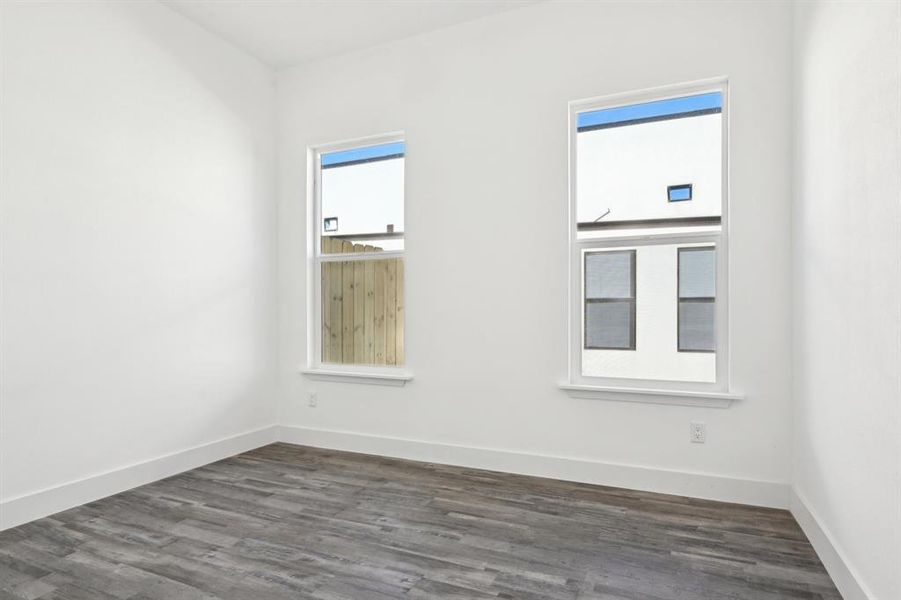 Unfurnished room with dark wood-style floors and baseboards