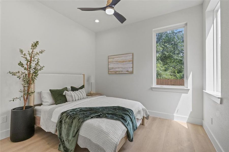 Bedroom with ceiling fan and light hardwood / wood-style flooring