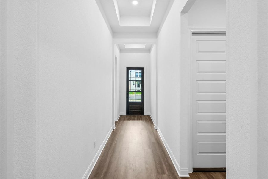 A well-lit entryway welcomes visitors with contemporary recessed lighting and durable wood flooring.