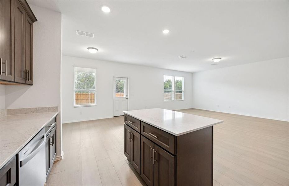 Large island overlooking gathering room and dining areas