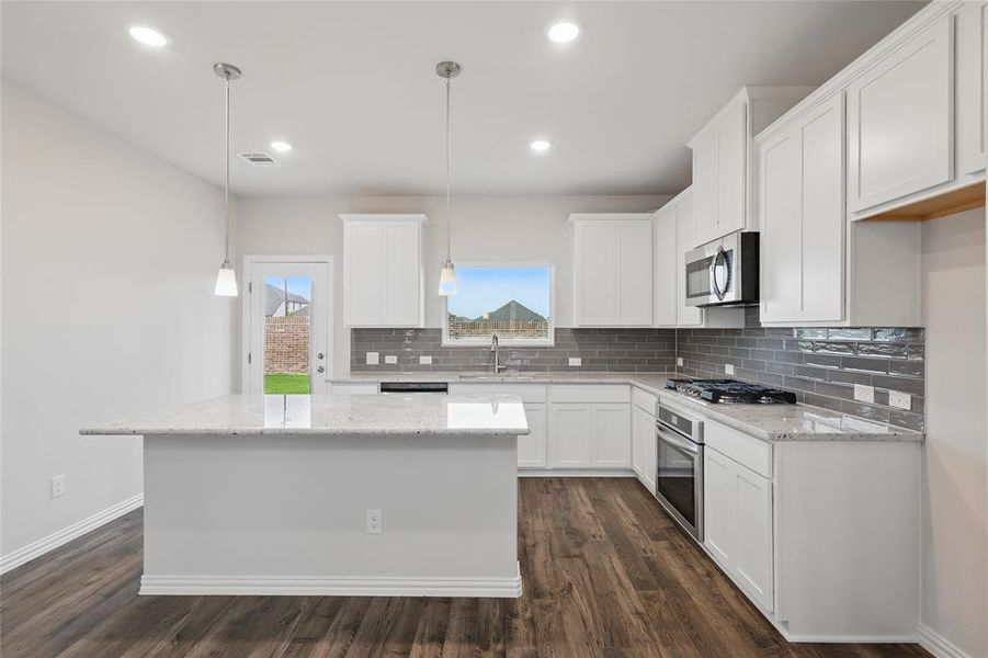 Kitchen featuring appliances with stainless steel finishes, tasteful backsplash, white cabinets, dark wood-style flooring, and recessed lighting