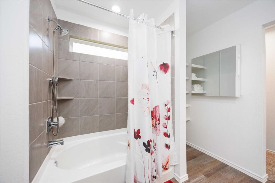 Primary Bath:Tiled tub/shower with built-in shelving and nearby linen storage. Primary Bath:Tiled tub/shower with built-in shelving and nearby linen storage.