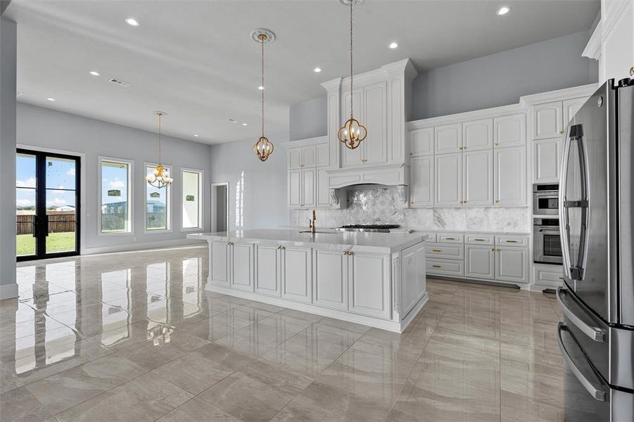 Kitchen featuring decorative backsplash, a chandelier, stainless steel appliances, white cabinetry, and recessed lighting Kitchen featuring decorative backsplash, a chandelier, stainless steel appliances, white cabinetry, and recessed lighting