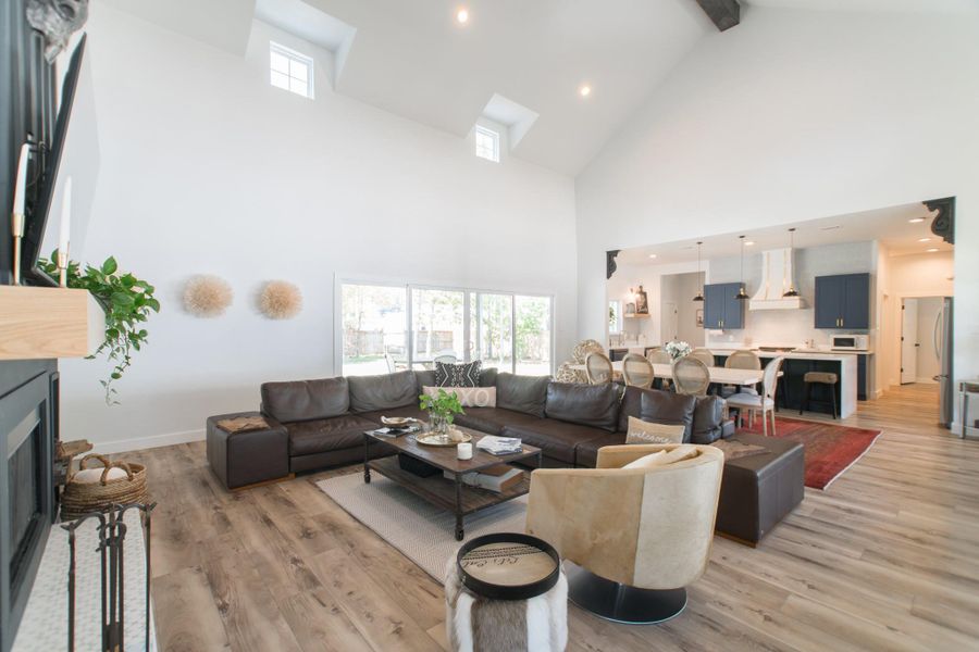 A grand living room with large windows, recessed lighting, and a striking wood-beamed ceiling A grand living room with large windows, recessed lighting, and a striking wood-beamed ceiling
