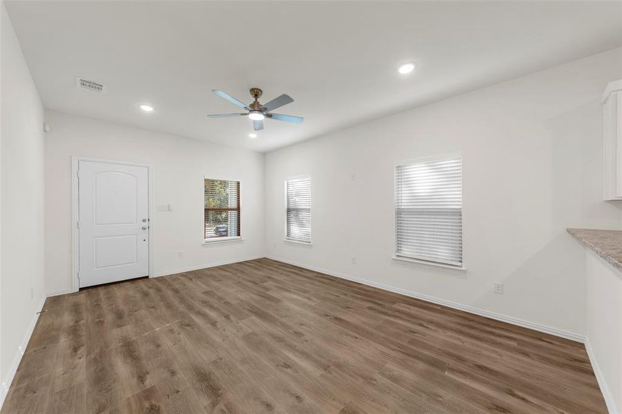 Unfurnished living room featuring hardwood / wood-style flooring and ceiling fan