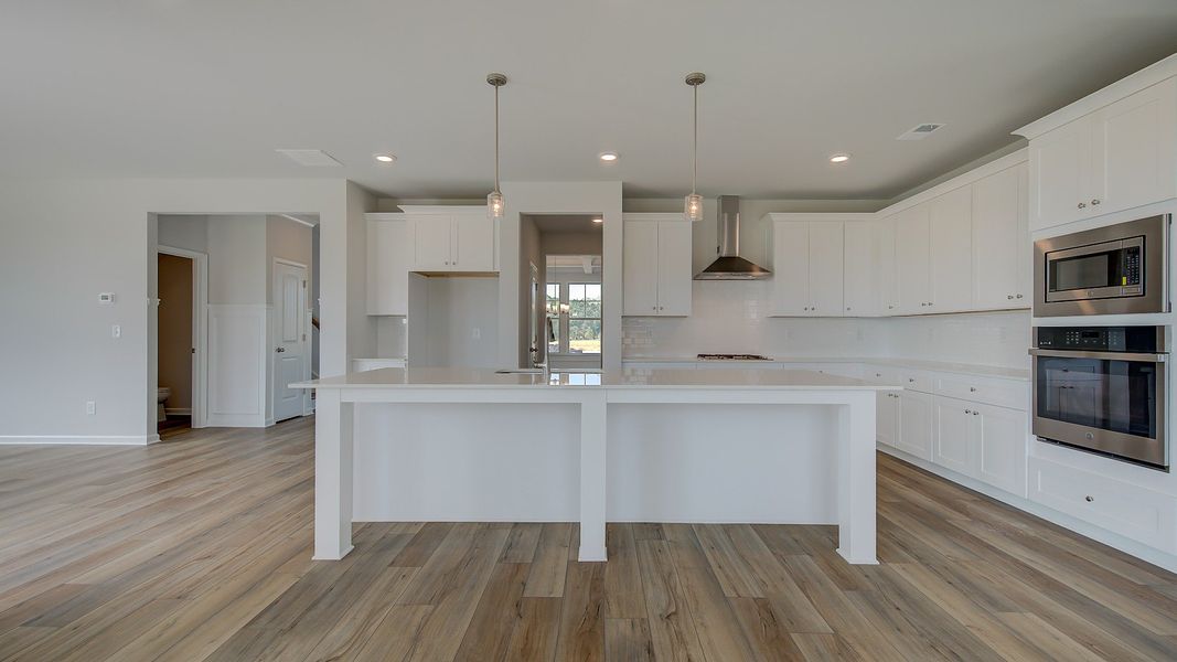 Stonefield open-concept kitchen with expansive island, neutral modern finishes, and pendant lighting at Brighton.