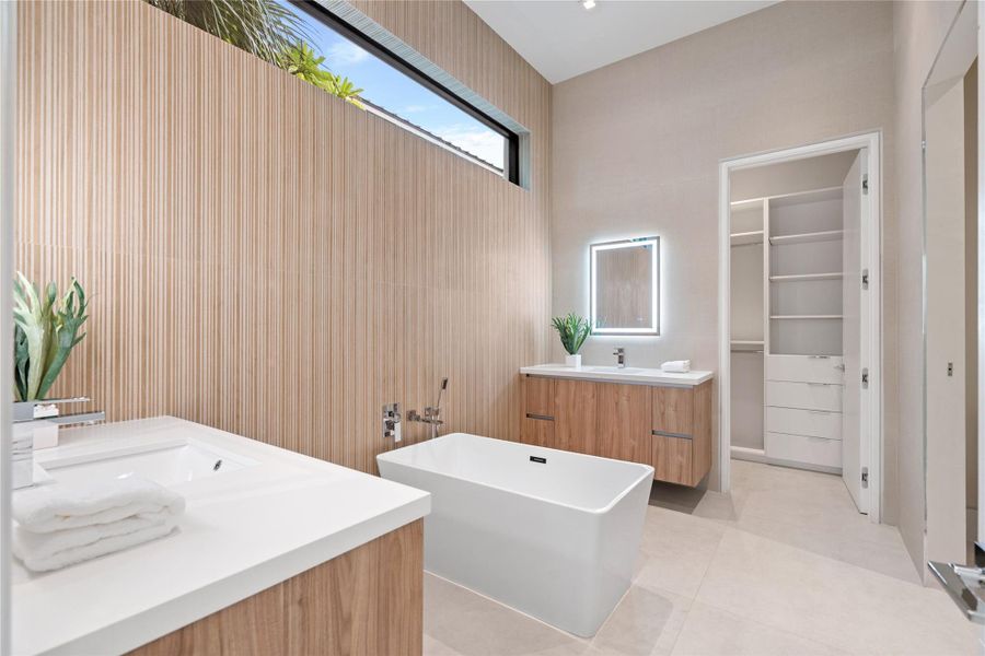 Elegant guest suite bathroom with floating vanities, freestanding soaking tub, and sleek modern finishes. Elegant guest suite bathroom with floating vanities, freestanding soaking tub, and sleek modern finishes.