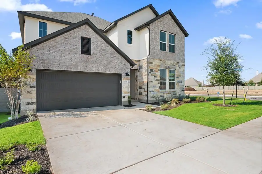 Front exterior of a new home in Park Collection At Wolf Ranch, Georgetown, TX, highlighting curb appeal (Image 1).