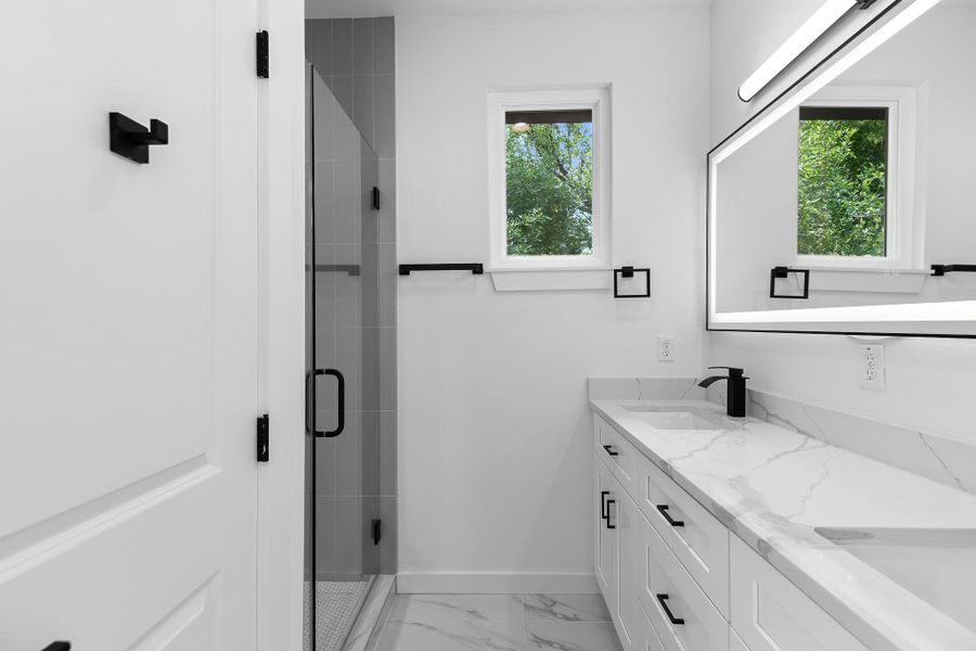 Clean lines and bright finishes create a modern aesthetic in this well-appointed bath.