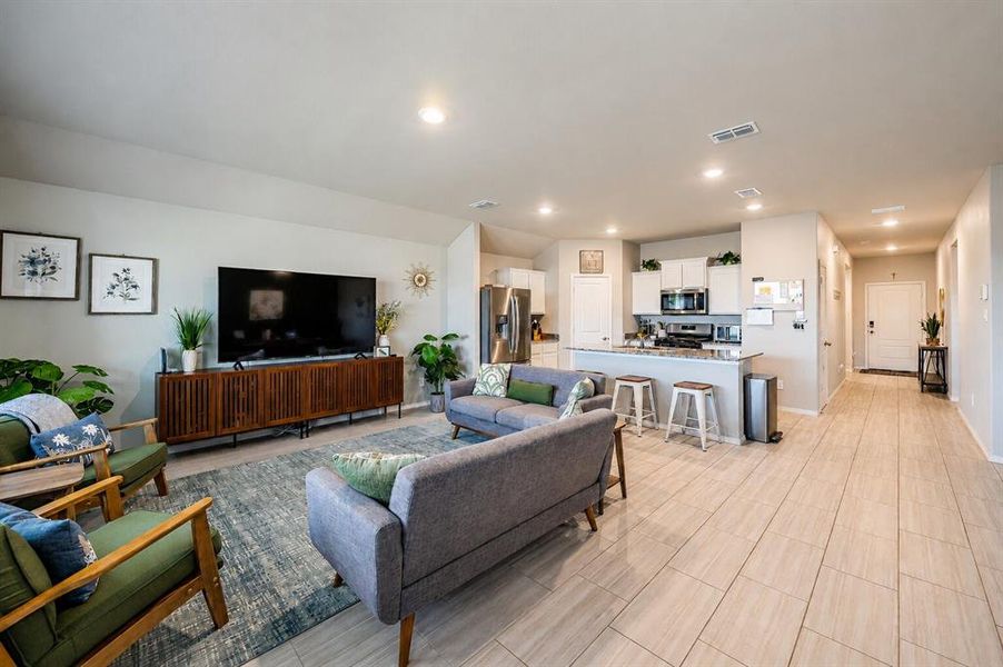 Open-concept living space featuring wood-finish flooring throughout the entry and kitchen