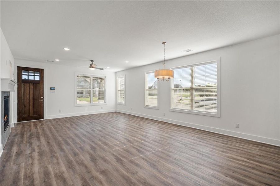 This Living and Dining area us where there will be lots of warm and cozy moments with this beautiful lit fireplace. Living room has a ceiling fan, LVP wood-style flooring, recessed lighting & lots of windows for natural lighting.