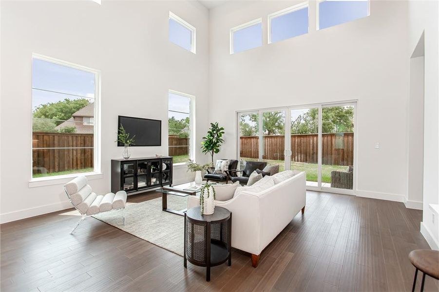 Living room featuring dark hardwood / wood-style flooring and a towering ceiling