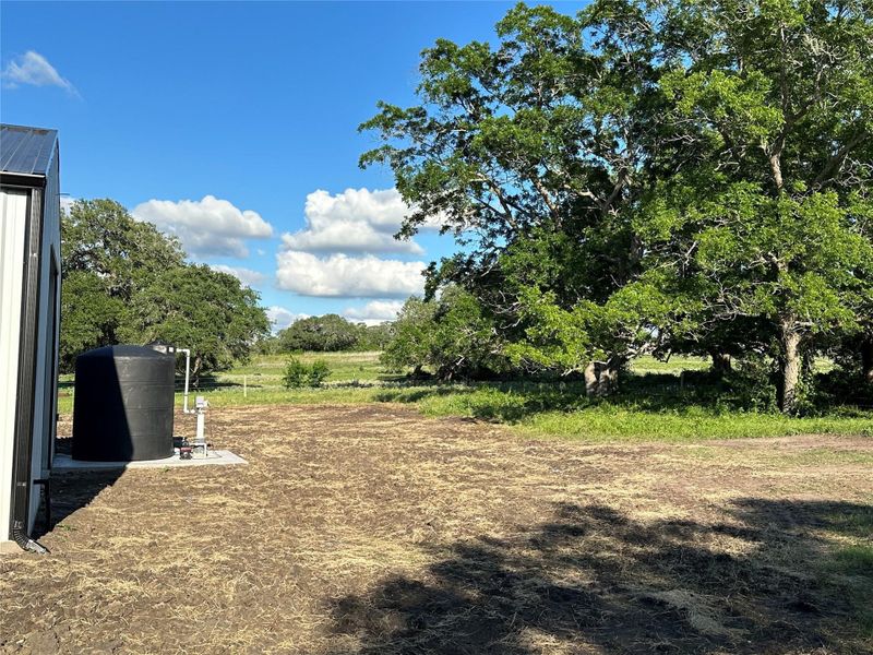 1K gallon holding tank for well.  Well has booster pump.  Several pecan trees in the back.