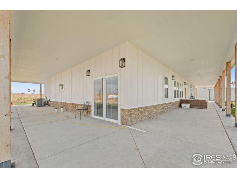 Sliding glass doors from the master suite open directly onto the wrap-around porch, blending indoor comfort with outdoor living and country views.