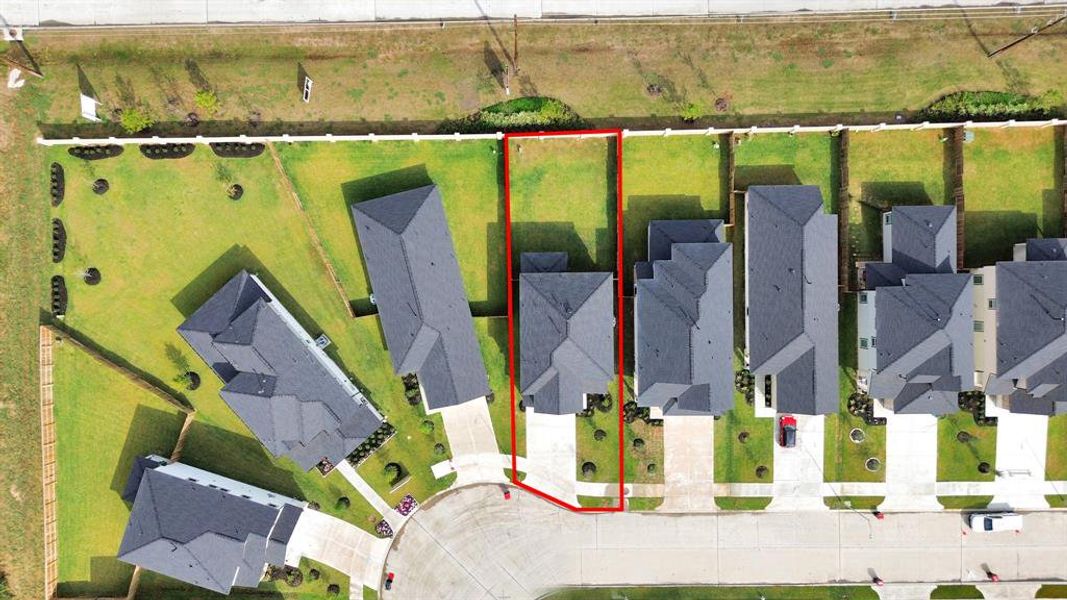 An aerial view of a spacious subdivision lot, highlighting a well-maintained yard and a fully fenced perimeter, offering both privacy and expansive outdoor space.