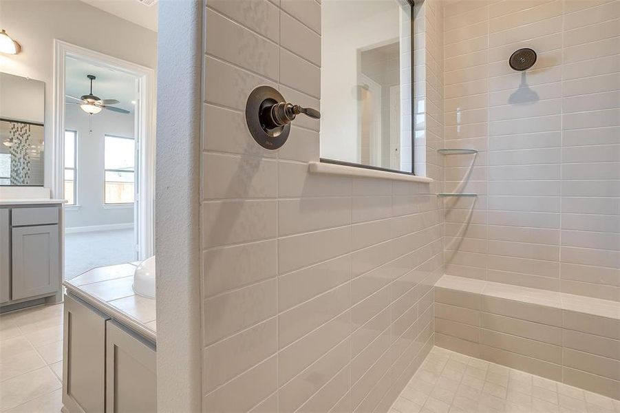 Bathroom featuring tile patterned flooring, ceiling fan, vanity, and tiled shower