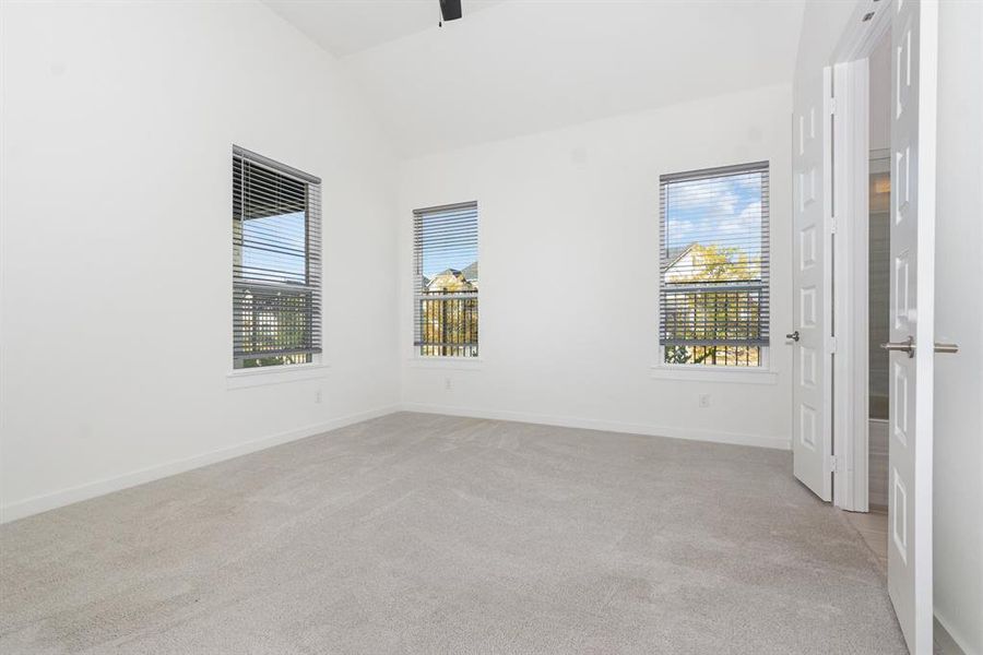 Spare room featuring lofted ceiling and light colored carpet Spare room featuring lofted ceiling and light colored carpet