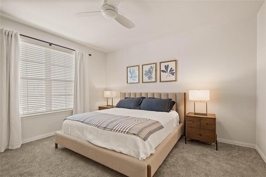 Bedroom with ceiling fan and light colored carpet